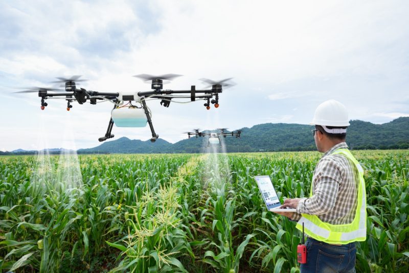 person operating a drone with sprayer