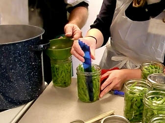 Photo of someone removing air bubbles from jars with a plastic patula.