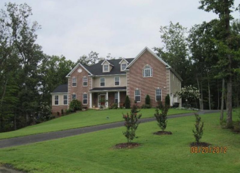 A two-story brick home with a freshly sodded, green lawn, indicating a quick upgrade in the yard's appearance.
