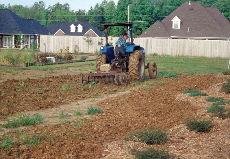Worker applying soil amendments.