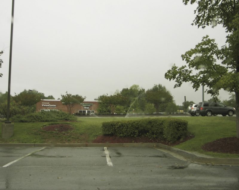 Photo of grass and parking lot on a rainy day.