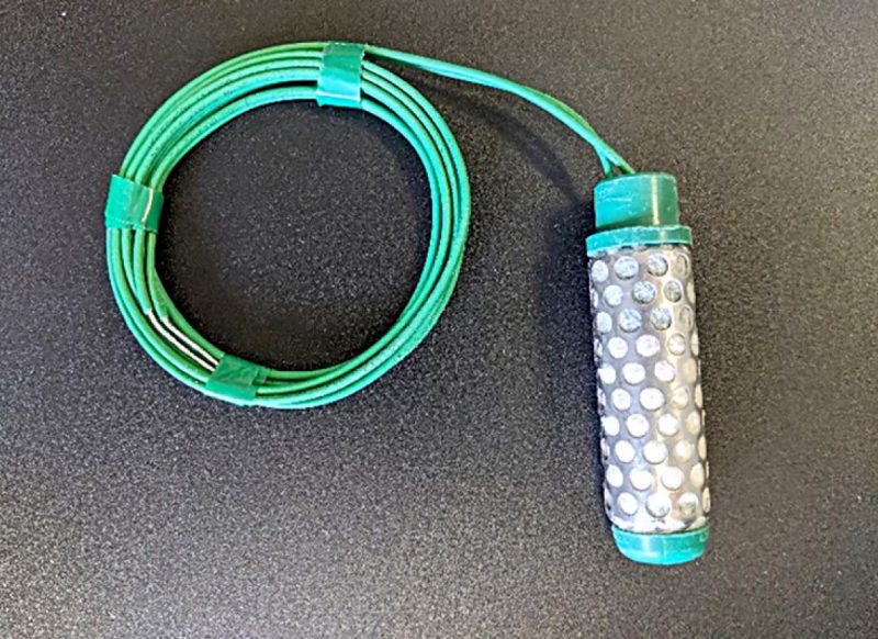 Photograph of an electrical resistance sensor with a green cord.