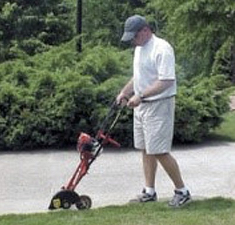 An image of someone demonstrating proper use of a lawn edger.