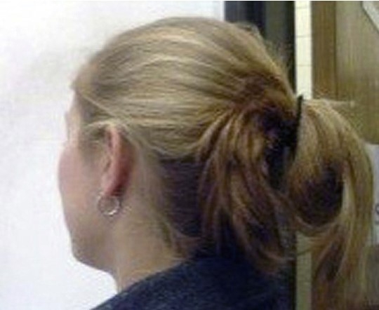 The back of a person's head depicting long hair tied up and off the shoulders.