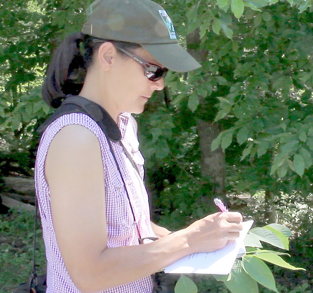 photo of a person writing a note in the woods