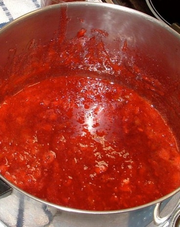 a photo of strawberries boling in a pot 