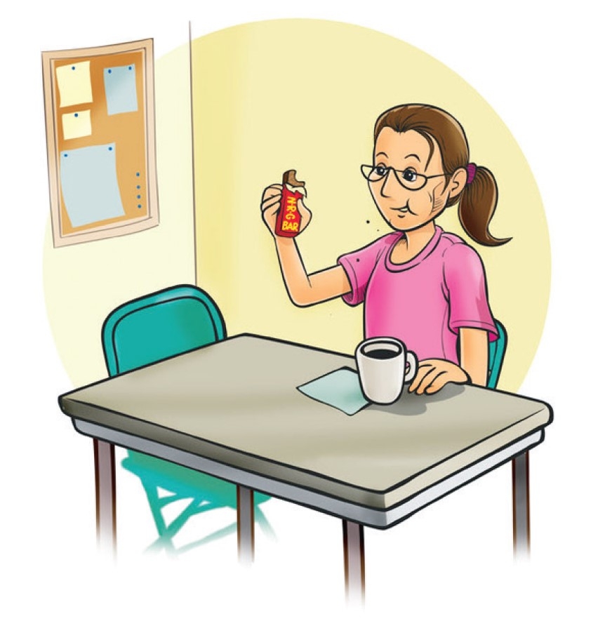 A worker setting on a table eating chocolate.