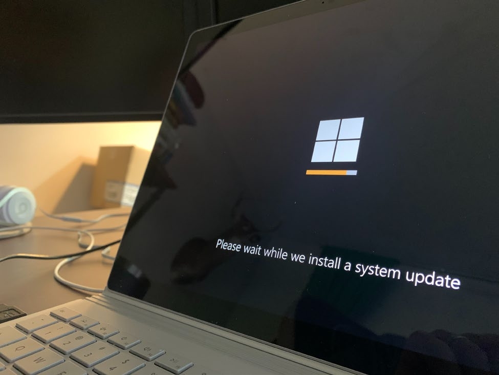 A picture containing a laptop with a screen showing an update is being installed.