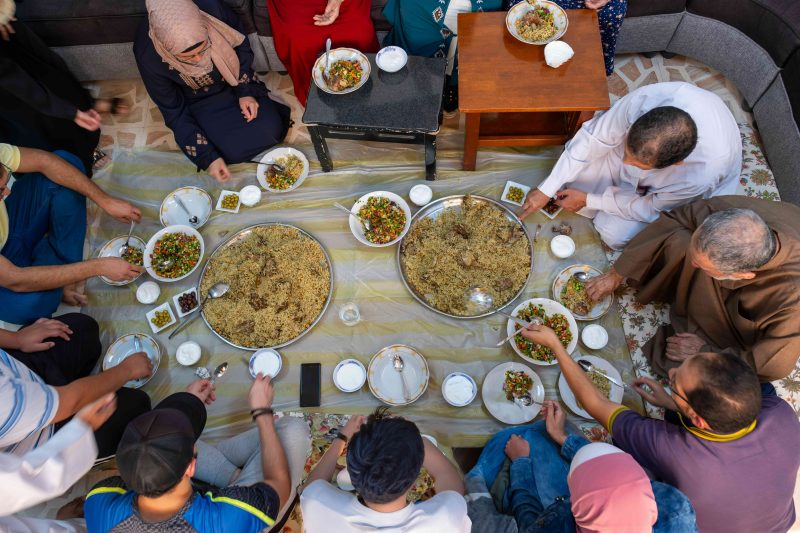 Overhead view of a large family eating a meal.