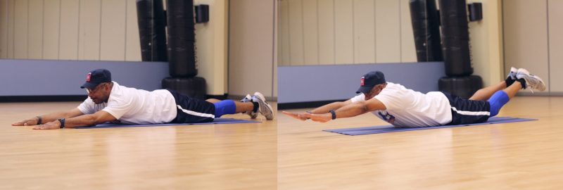 First image shoiwng a man lying on the floor with his arms extended out above his head, then on the other image he is lifting his legs and arms a few inches off the ground. A position that looks as though you're flying like a superhero.