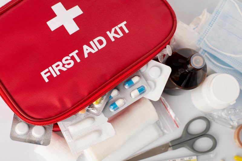 A red first aid kit and its contents.
